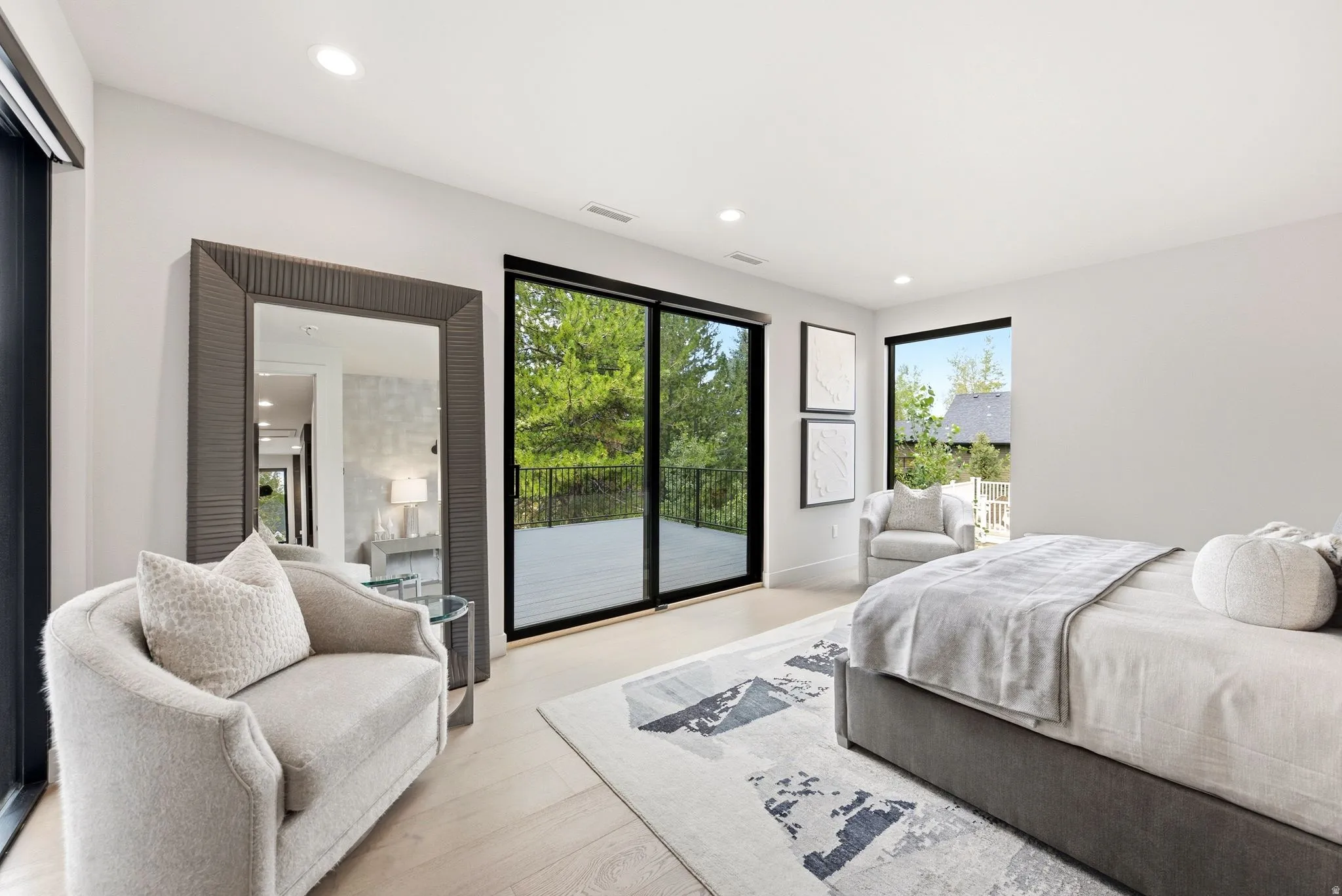 Light-filled room featuring wood-finish flooring, recessed lighting, and a large sliding glass door opening to a private deck