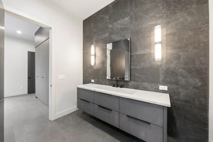 Floating vanity with a light countertop, integrated sink, and matte black faucet