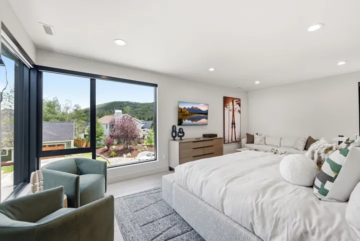 Expansive floor-to-ceiling windows featuring black frames and roller shades