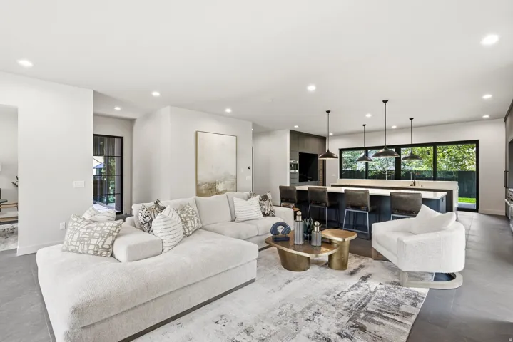 Open-concept living space featuring recessed lighting, a large kitchen island with seating, pendant lighting, and expansive windows