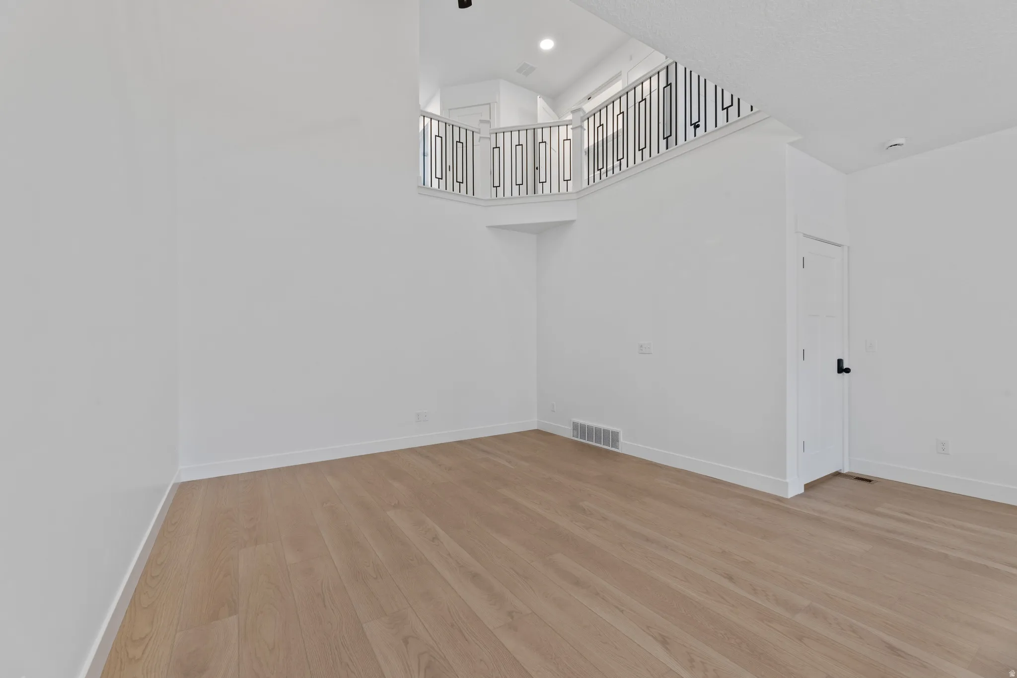 Bright, open-concept interior featuring light wood-finish flooring, white walls, and a recessed lighting fixture