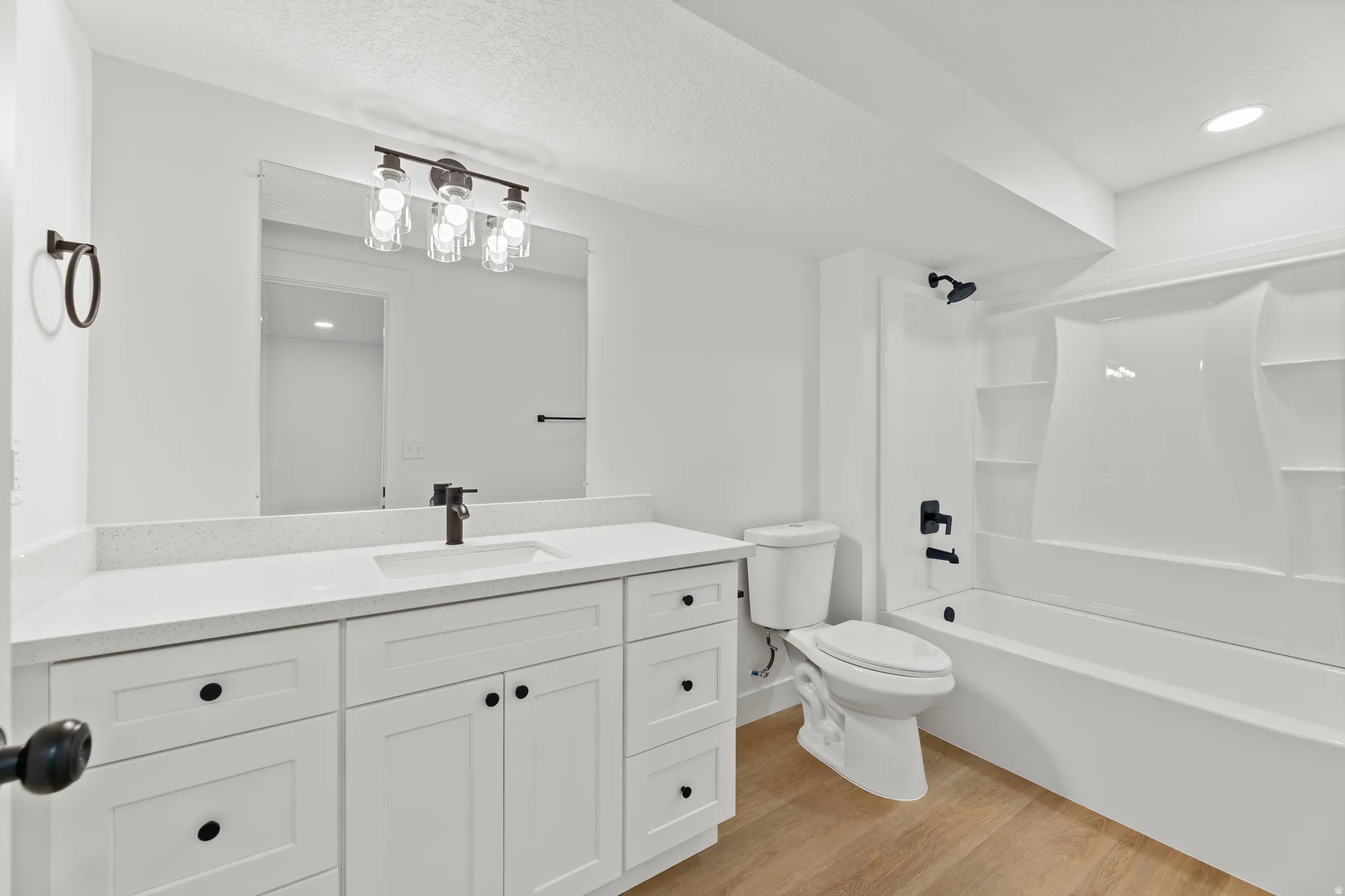Vanity featuring a white quartz-finish countertop, undermount sink, and matte black faucet