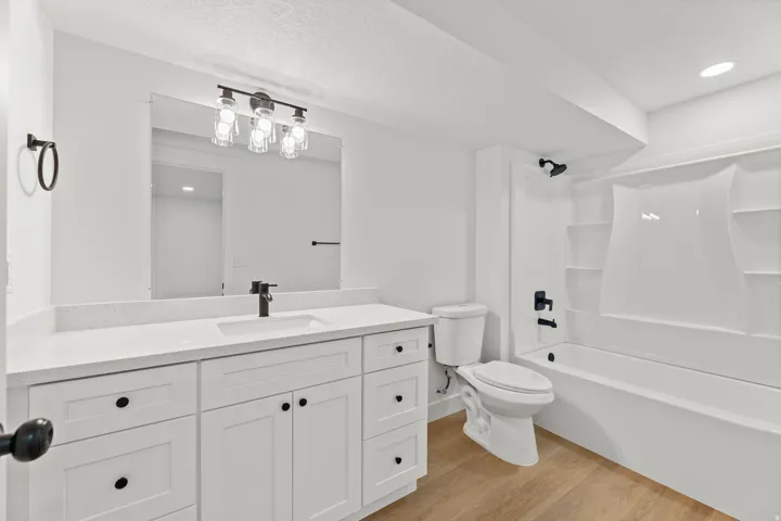 Vanity featuring a white quartz-finish countertop, undermount sink, and matte black faucet