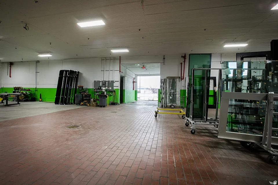 Spacious industrial interior featuring brick flooring, high ceilings with recessed lighting, and an overhead door