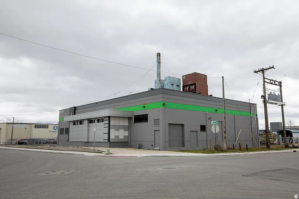 Commercial building with a grey facade and a green accent band