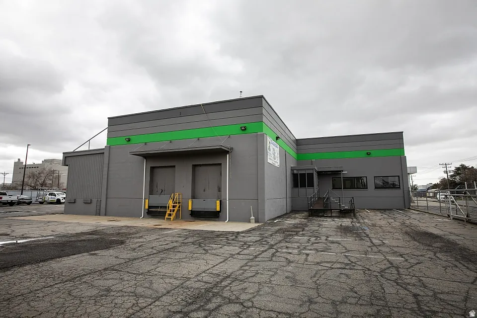 Commercial building with gray exterior and green accent banding