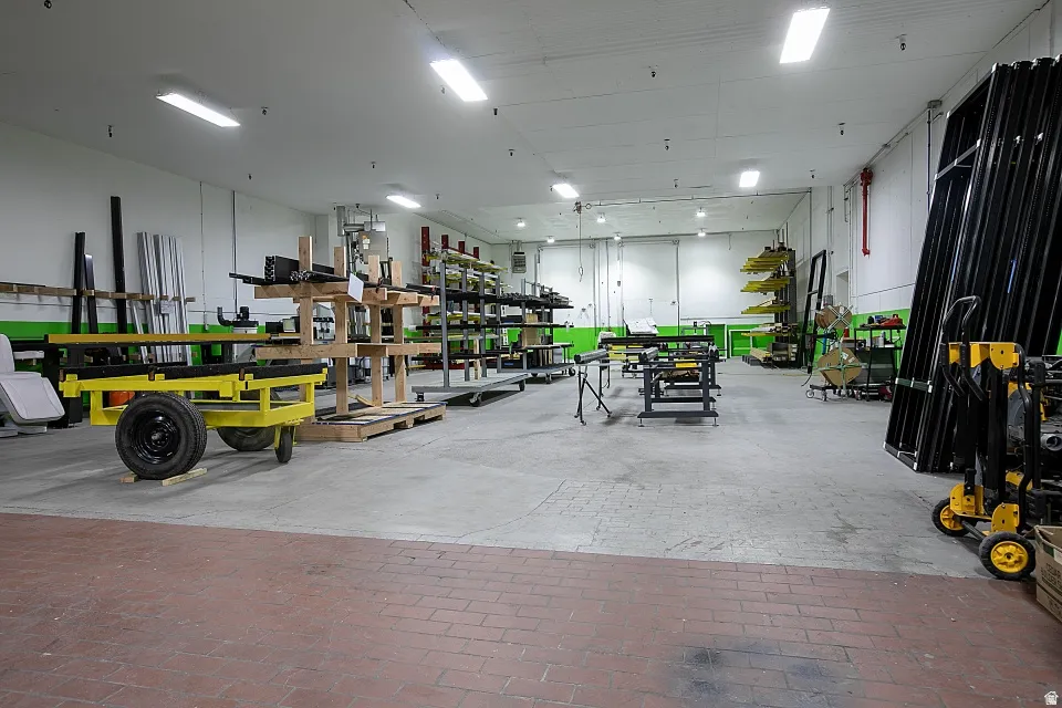 Spacious warehouse interior featuring a high ceiling with multiple fluorescent light fixtures