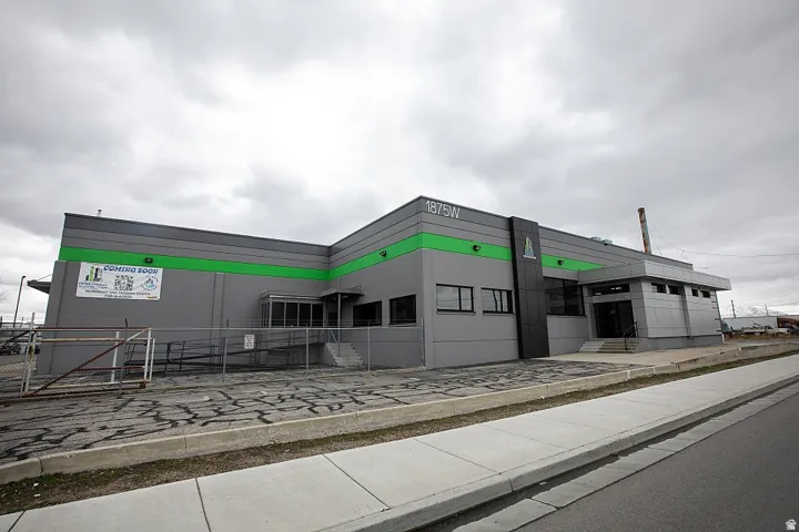 Industrial building with a gray facade accented by green banding
