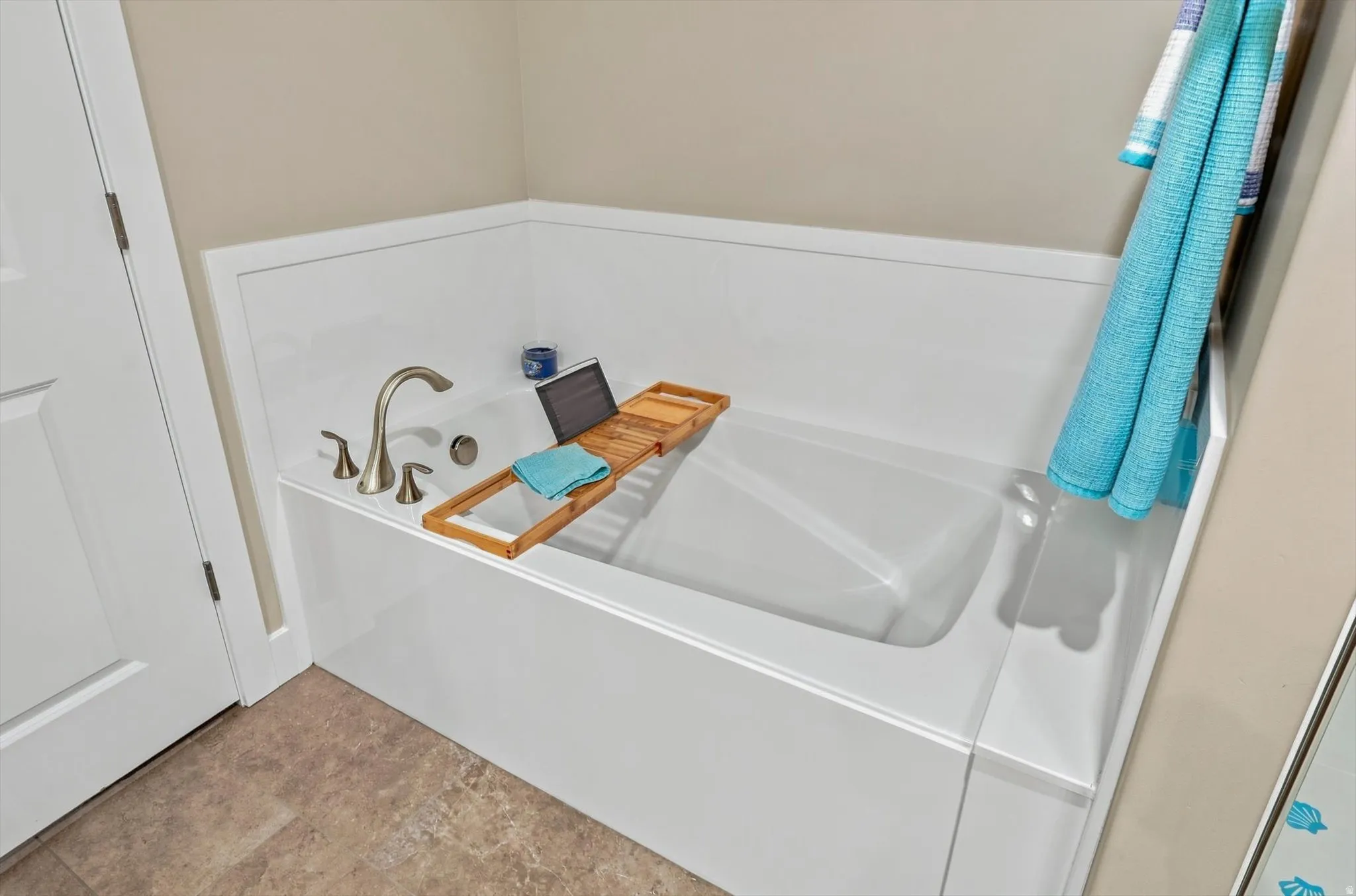 Alcove bathtub featuring a brushed nickel faucet, a white acrylic tub, and an integrated shower panel