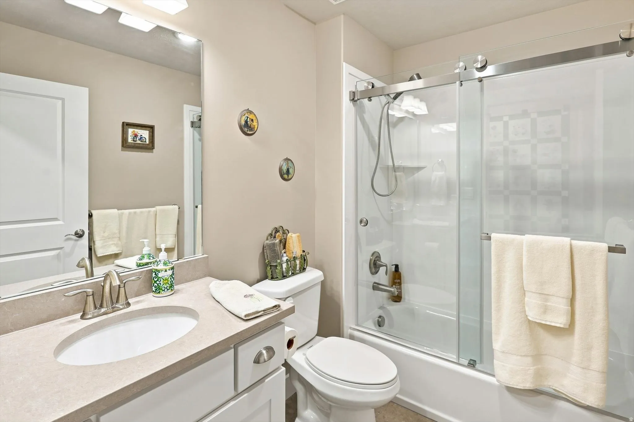 Bathroom featuring a white vanity with a light-toned countertop, an undermount sink, and a brushed nickel faucet