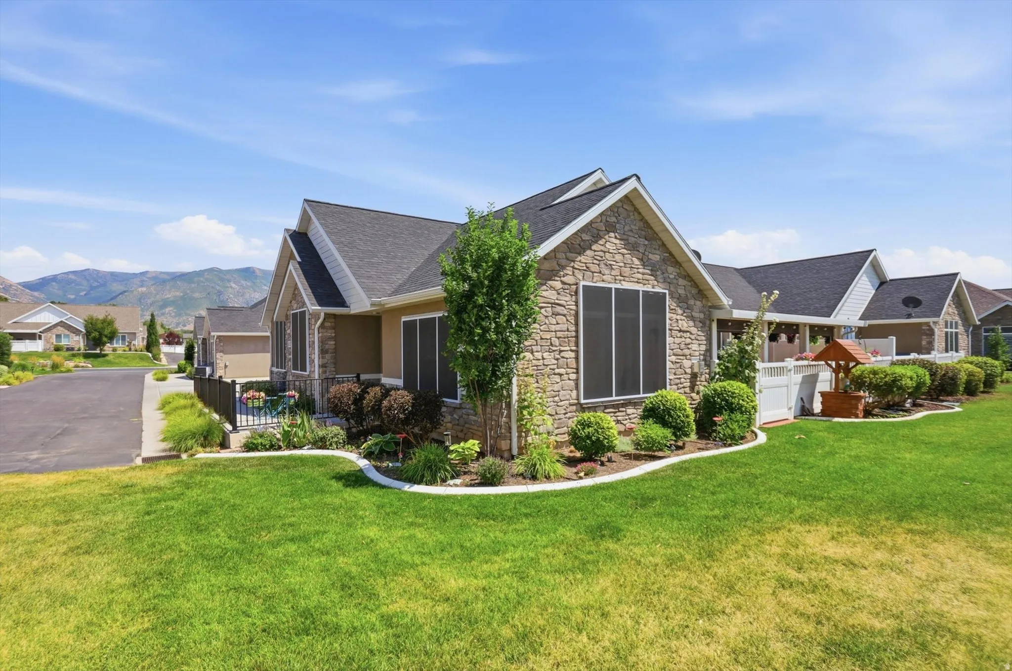 Stone veneer exterior with dark shingle roofing