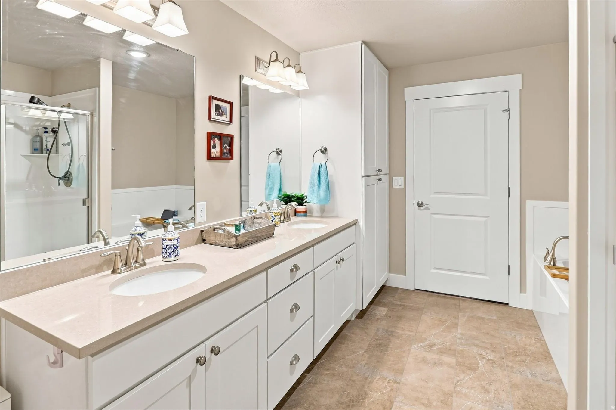 Bathroom featuring a double vanity with light-toned countertops, undermount sinks, and brushed nickel fixtures