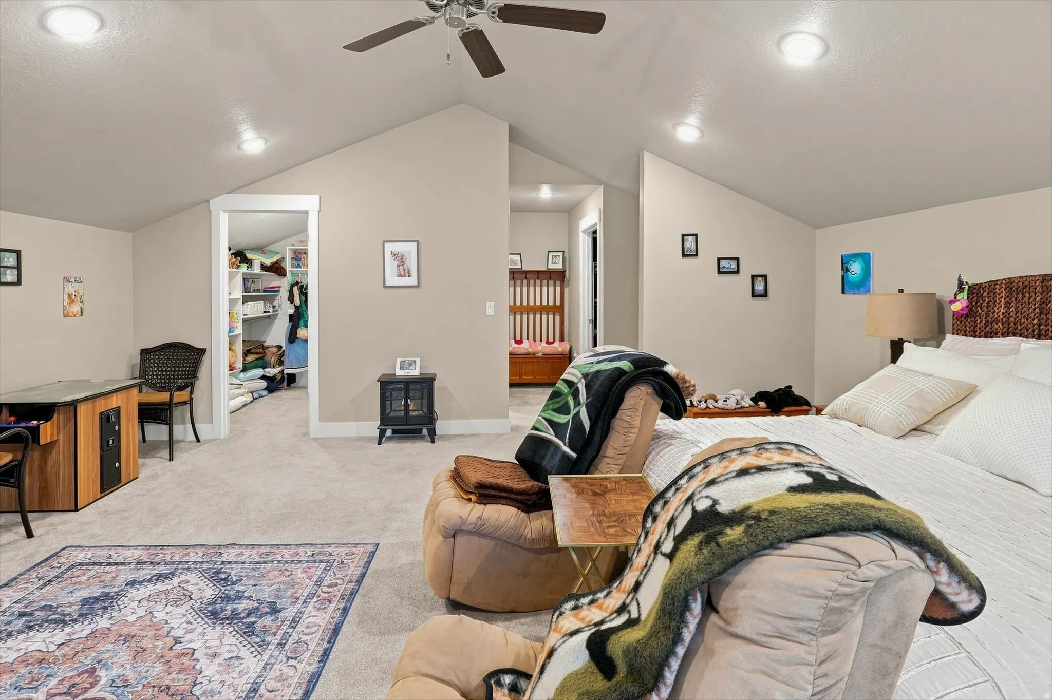 Spacious room featuring vaulted ceilings, recessed lighting, carpet flooring, and a ceiling fan