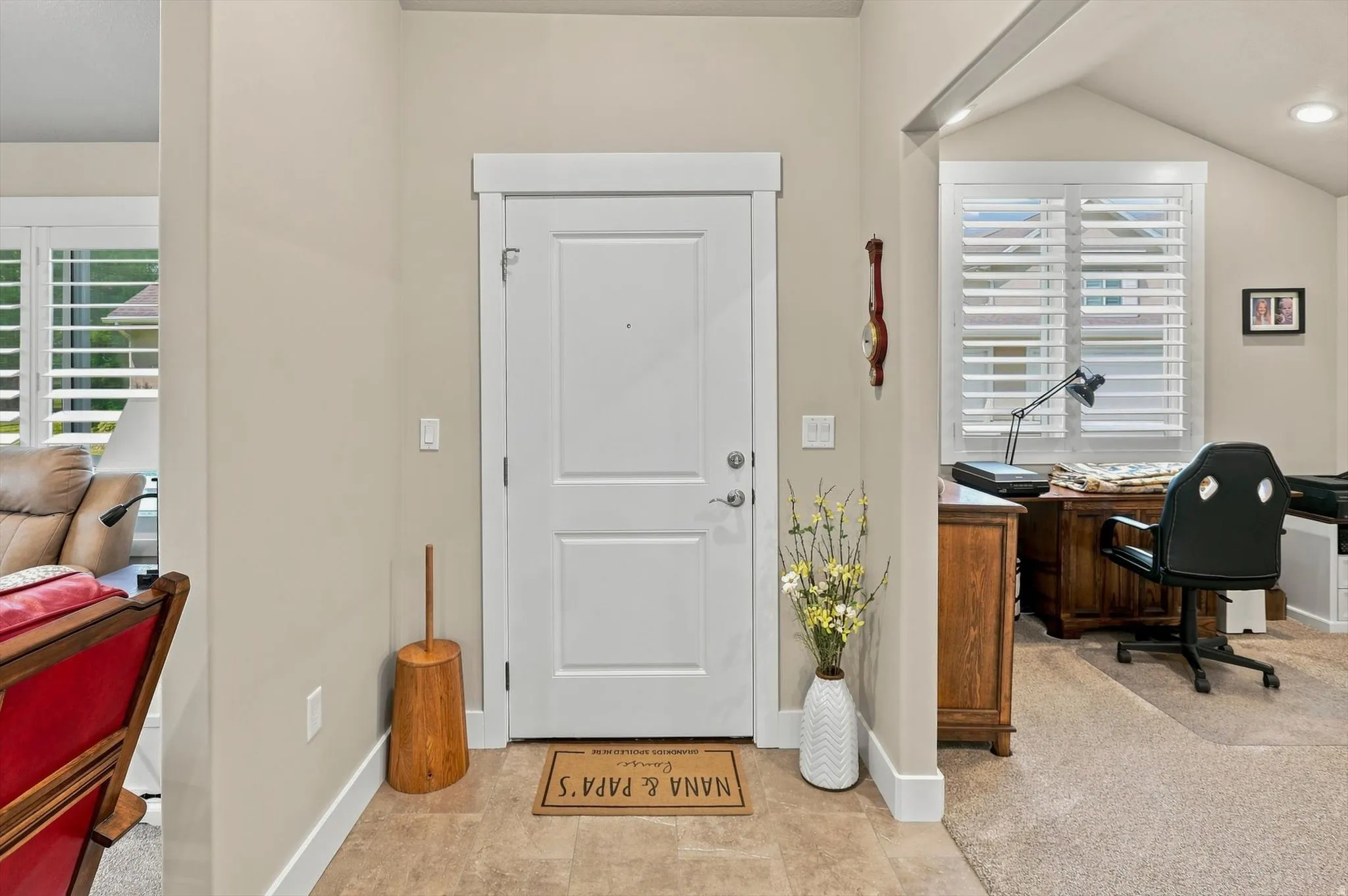 Entryway featuring a white paneled door with brushed nickel hardware
