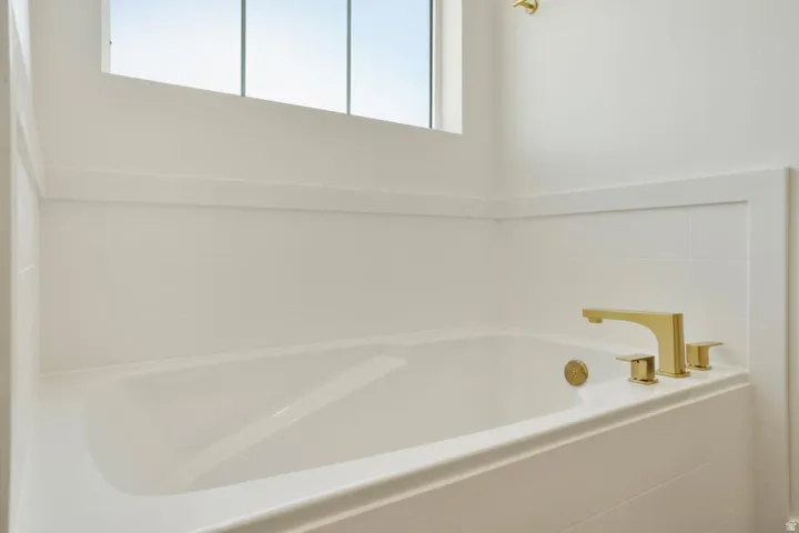 Soaking tub with a polished brass faucet set
