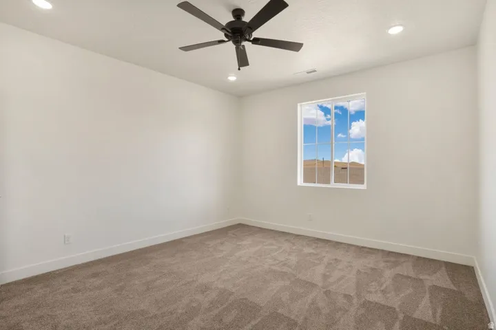 Bedroom featuring a window with grid detailing, recessed lighting, and a ceiling fan
