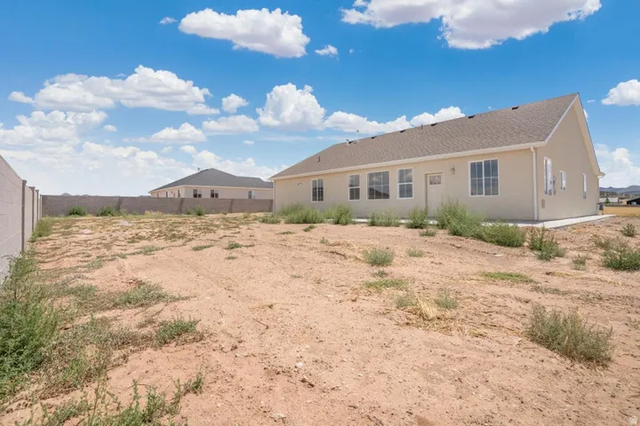 Expansive property grounds featuring a concrete slab foundation, multiple windows, and a side entry door