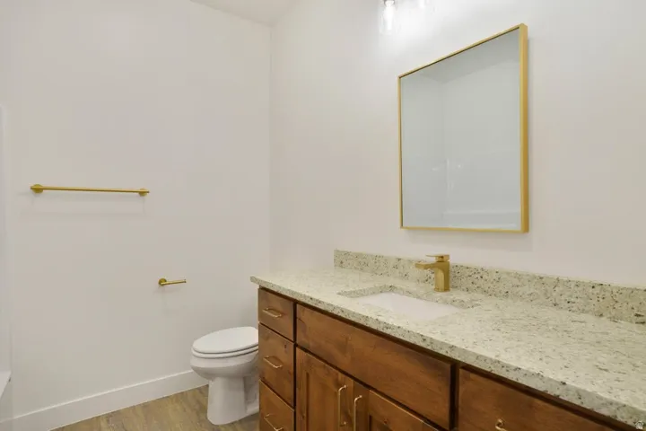 Bathroom featuring a single vanity with wood cabinetry, a light-colored countertop, and a rectangular undermount sink