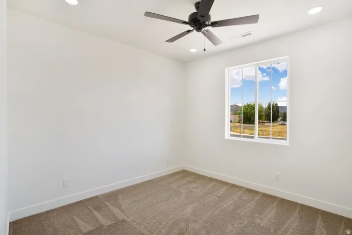 Bedroom featuring a contemporary ceiling fan, recessed lighting, and a large window