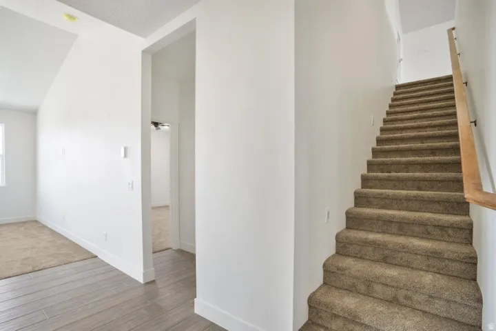 Carpeted staircase with a wood-finish handrail
