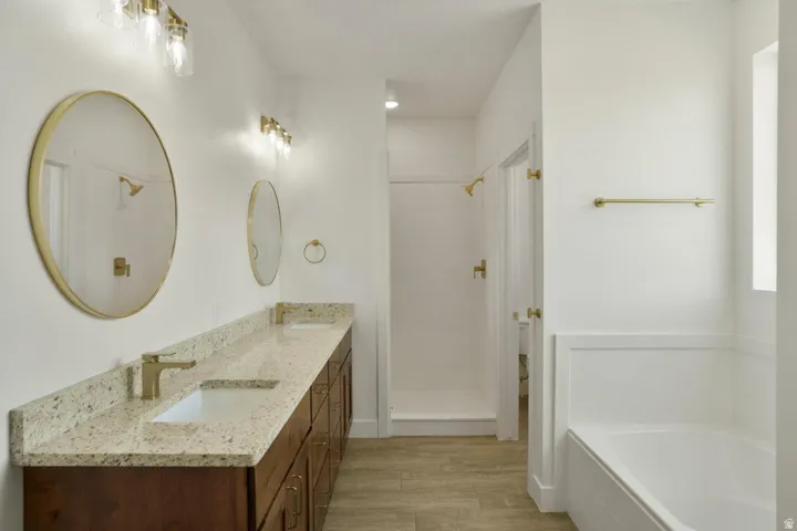 Double vanity featuring a light-toned countertop, integrated sinks, and gold-finish fixtures