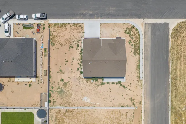 Newly constructed residence featuring a brown shingle roof, concrete driveway, and concrete sidewalk