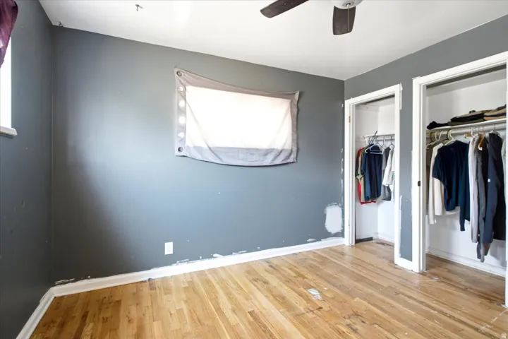 Hardwood-finish flooring with dual closet entries and a ceiling fan