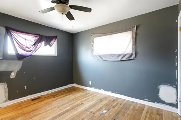 Hardwood flooring, painted walls, and an overhead ceiling fan with light kit