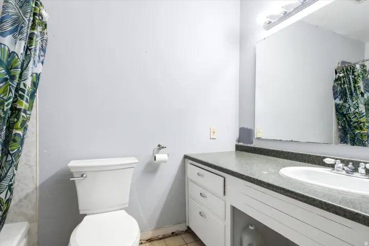 Bathroom featuring a vanity with a built-in sink, an overhead mirror, and a toilet