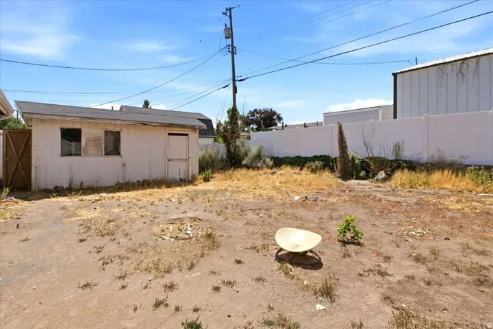 Rear yard featuring a storage shed with a sloped roof and two window openings