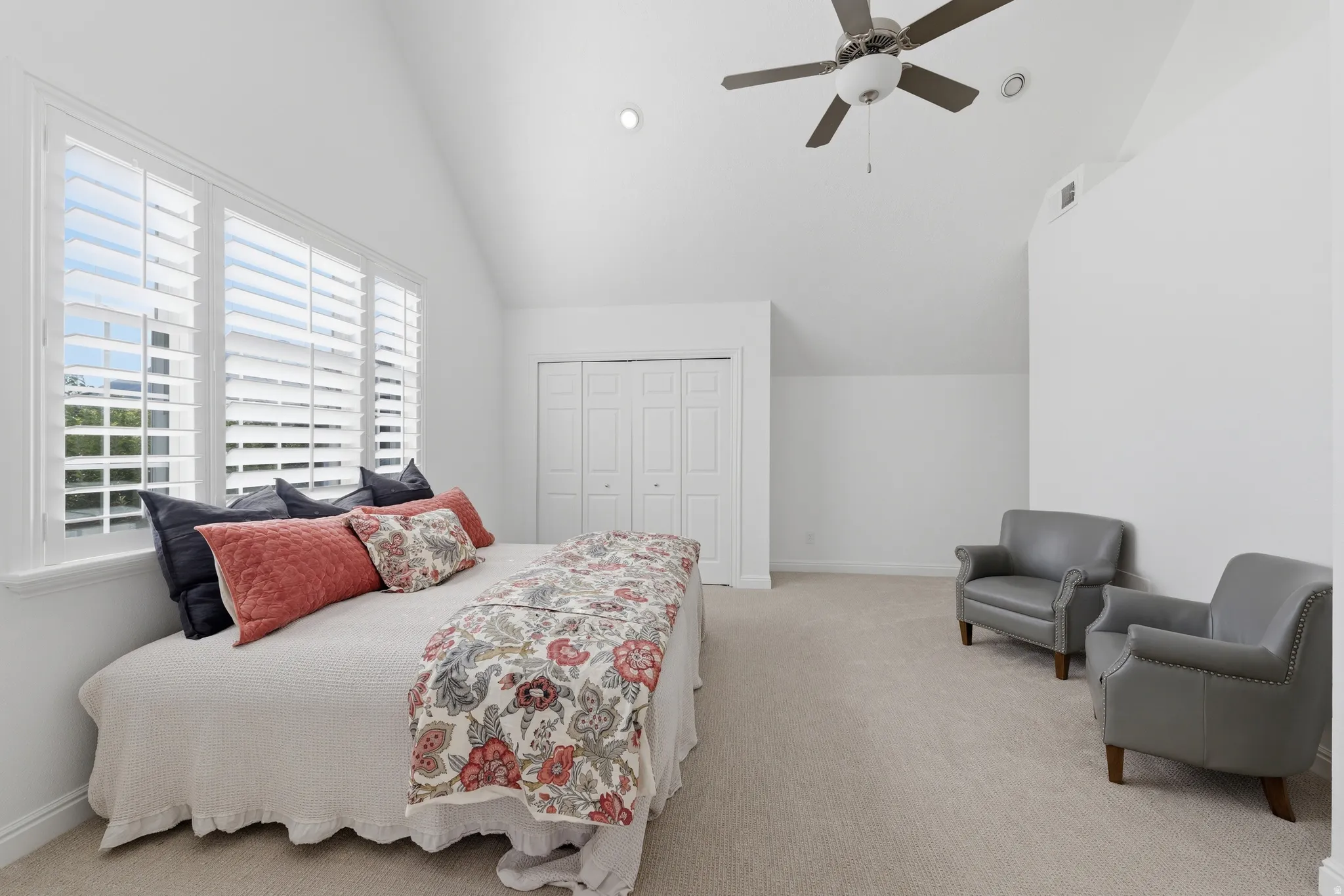 Primary bedroom with vaulted ceiling featuring plantation shutters, a ceiling fan, recessed lighting, and a double-door closet with additional storage