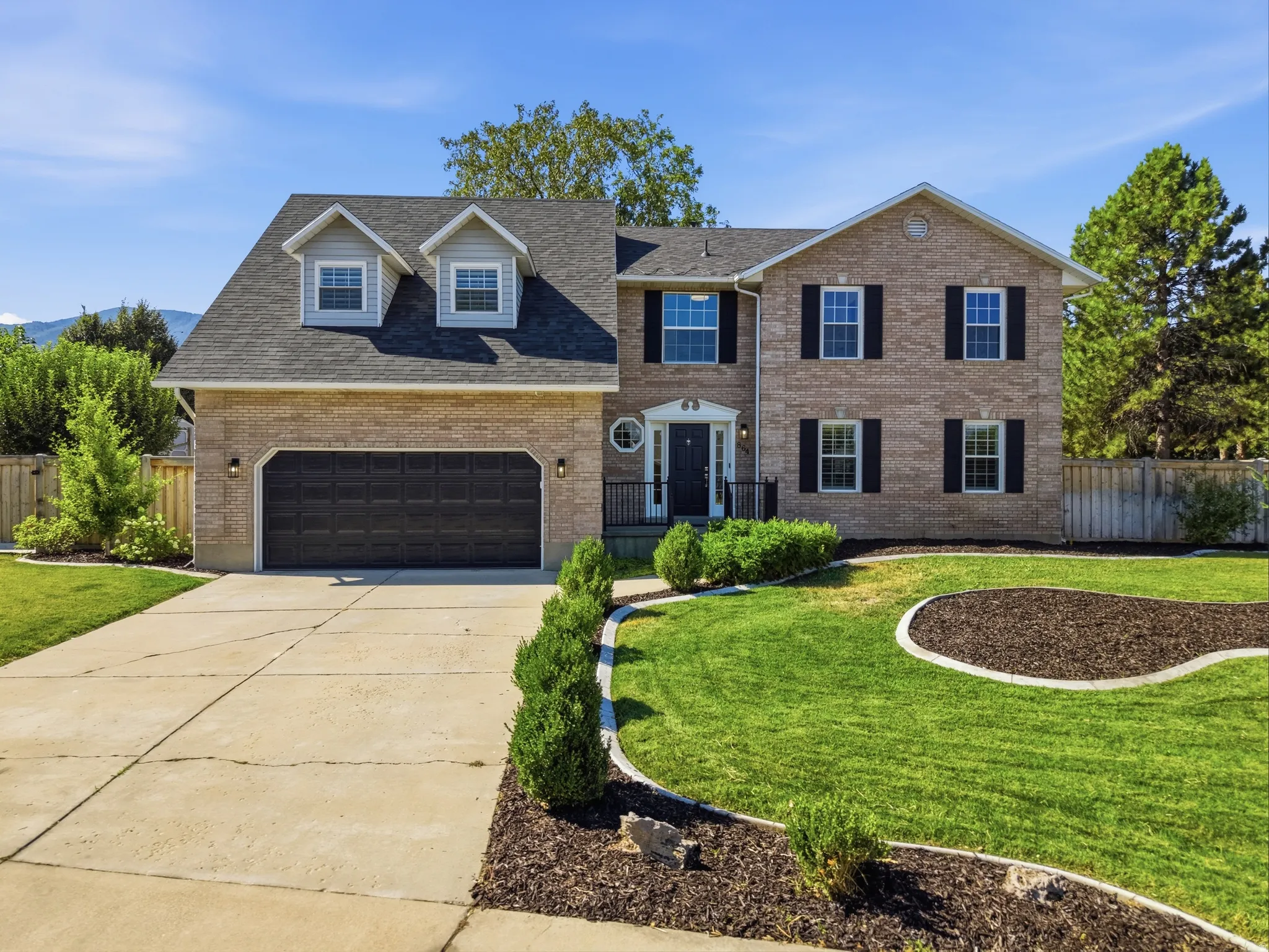 Brick exterior featuring dormer windows and black shutters