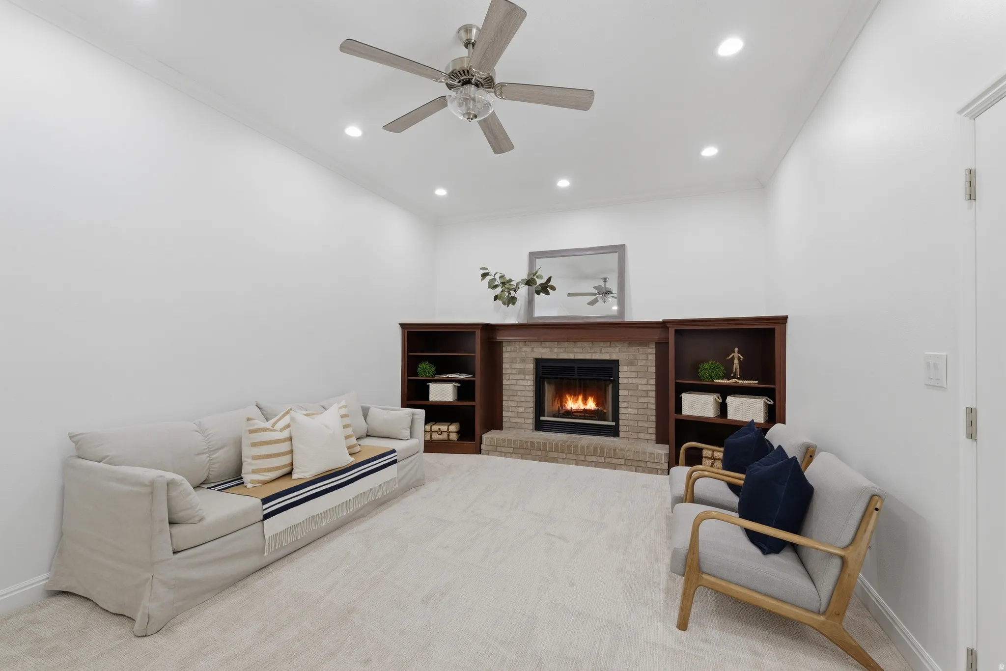 Living space featuring a woodburning fireplace with brick surround, wood mantel, and built-in shelving