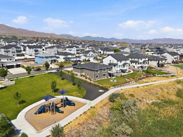 Expansive residential neighborhood with varied architectural styles, a community playground, and a clear mountain backdrop