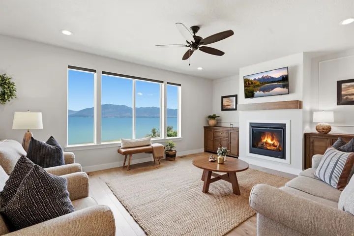 Expansive windows frame a prominent body of water and distant mountains