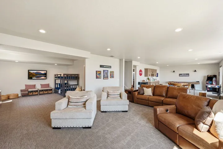 Spacious recreational area featuring recessed lighting, a built-in wet bar with light wood-finish cabinetry, and a carpeted floor