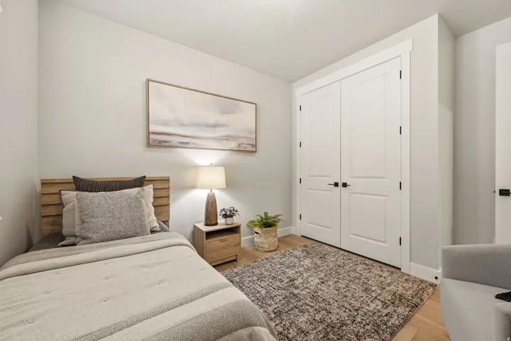 Light wood-finish flooring, white paneled doors with black hardware, and crisp white trim