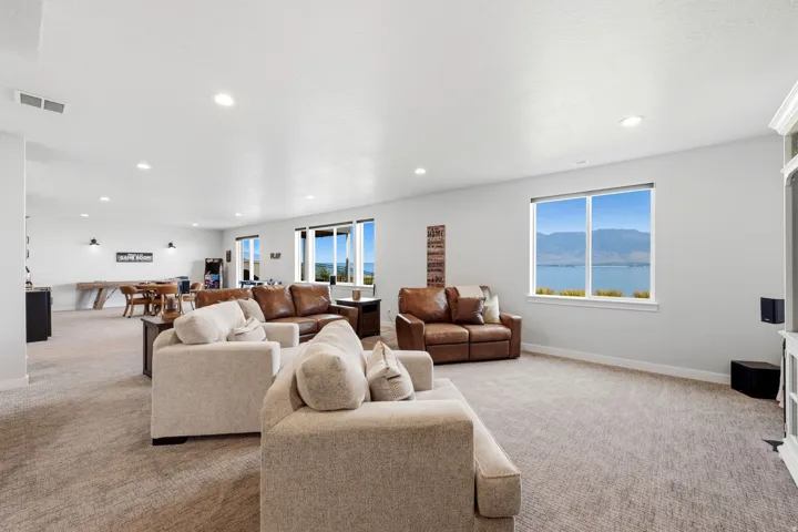 Spacious room with recessed lighting, large windows, and neutral carpeting