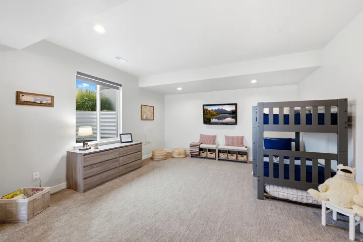 Recessed lighting, wall-mounted display, and light-toned carpet flooring