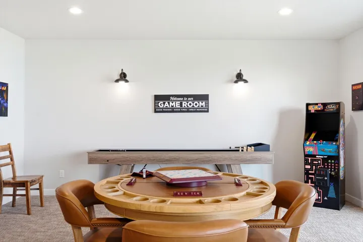 Recessed ceiling lighting, wall-mounted sconces, light-colored walls, and neutral carpet flooring