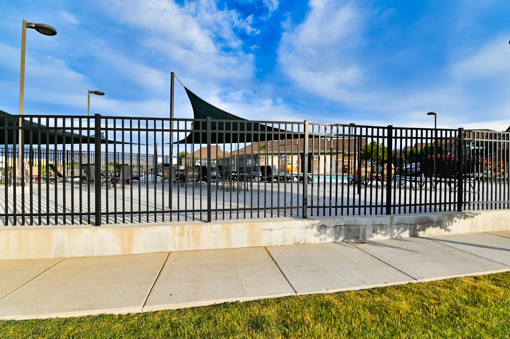 Fenced community pool area with partial shade coverings