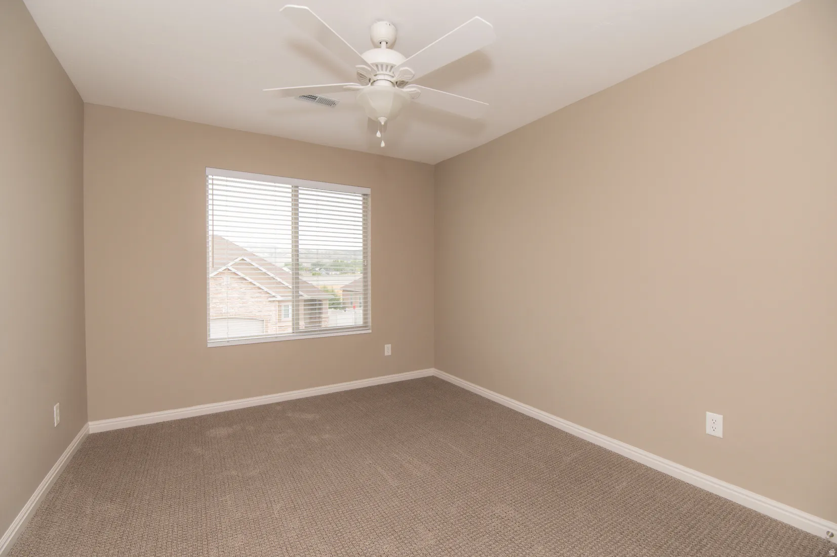 Bedroom featuring neutral-toned walls, carpeted flooring, and white baseboards