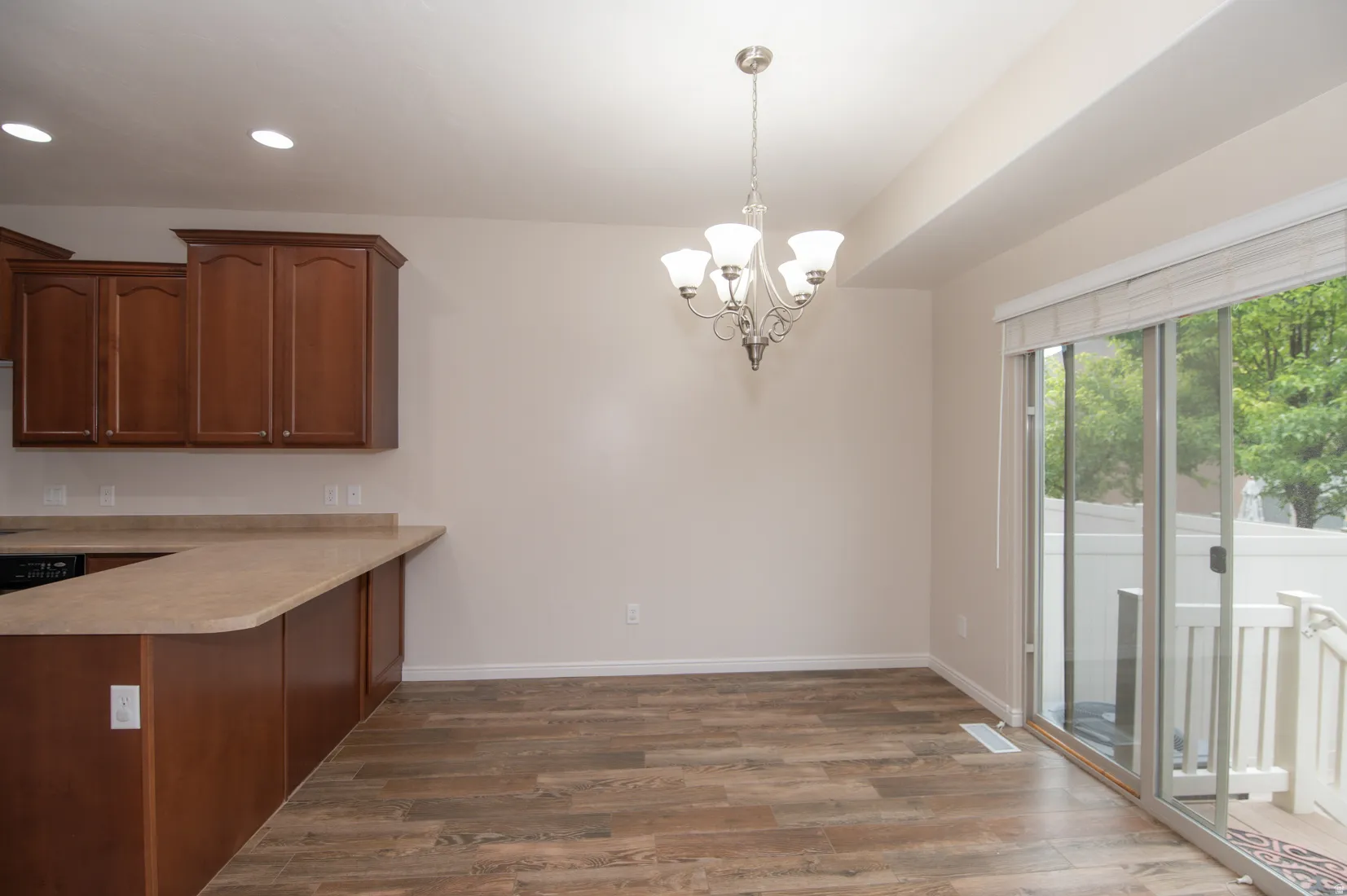 Kitchen and dining area featuring wood-finish flooring, recessed lighting, and a five-light chandelier