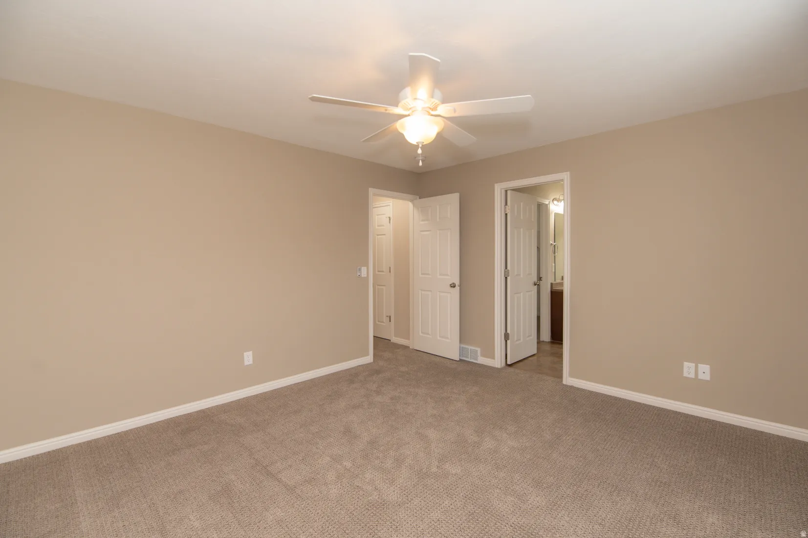 Carpeted interior space with neutral wall tones