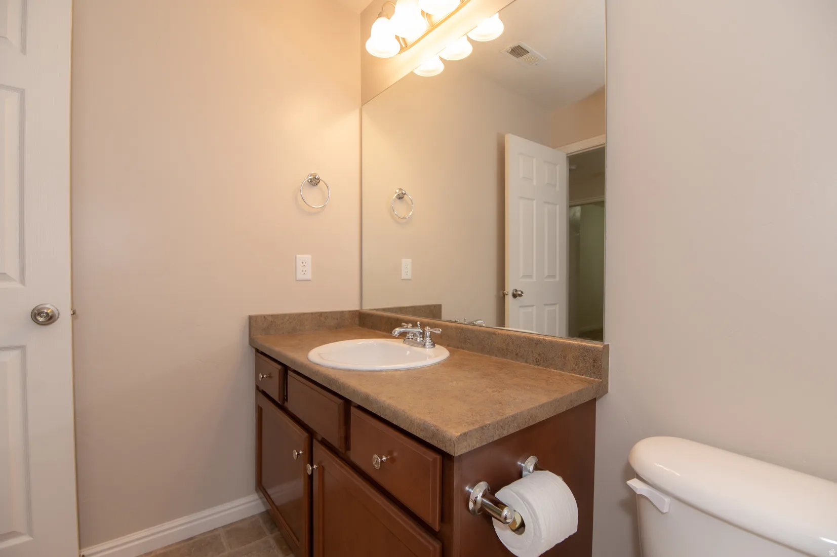 Bathroom vanity with a composite countertop, an undermount sink, and a chrome faucet