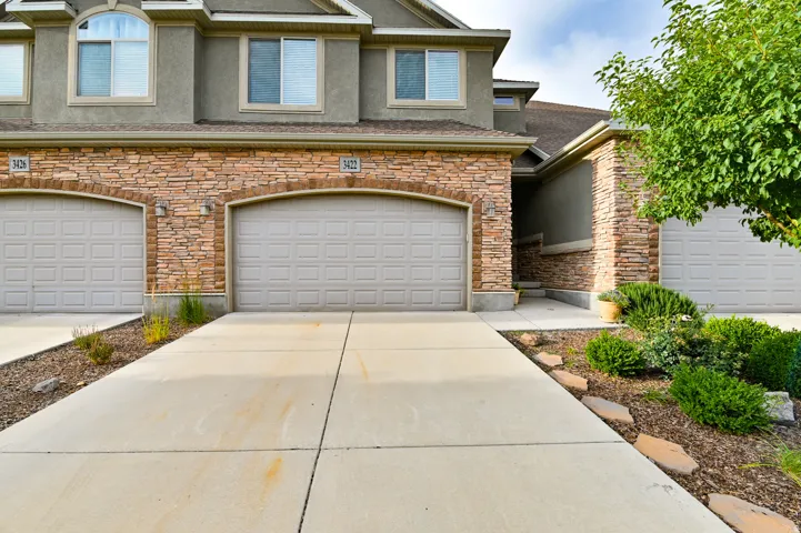 Concrete driveway leading to an attached two-car garage with panel doors