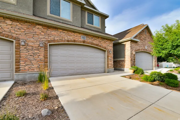 Stone veneer facade featuring arched garage door openings