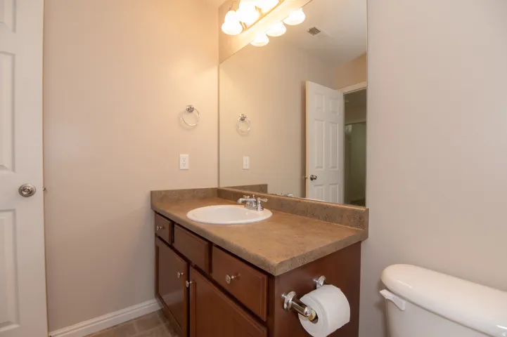 Bathroom vanity with a composite countertop, an undermount sink, and a chrome faucet