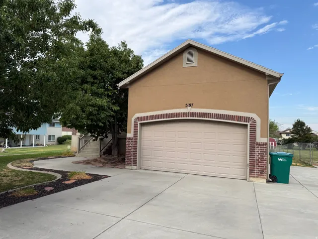 Stucco exterior with brick detailing over a two-car garage