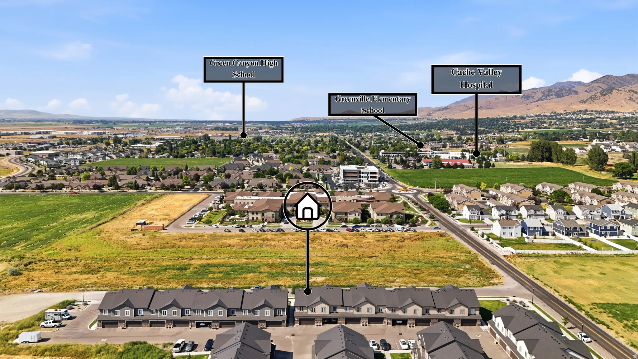 Aerial perspective highlighting the property within a residential setting, featuring mountains in the background and a road in the foreground